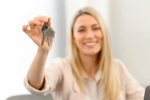 Selective focus on the keys with keychain in form of small cute house in hand of Stock Photos