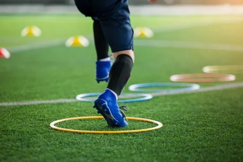 Selective focus to kid soccer player Jogging and jump at ring ladder marker o Stock Photos