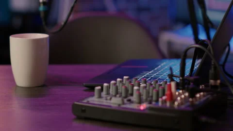 Selective focus on laptop keyboard and knobs of audio mixer on podcasting desk Video stock 190394887