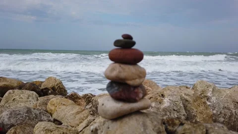 Selective focus. Large sea waves with white foam. tower of stones, stone pyramid Vídeos de archivo 137961080