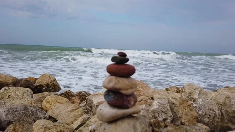 Selective focus. Large sea waves with white foam. tower of stones, stone pyramid Stock Footage 137961089