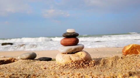 Selective focus. Large sea waves with white foam. tower of stones, stone pyramid Stock Footage 137961093