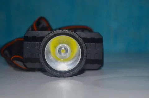 Selective focus LED headlamp on isolated blue background Stock Photos