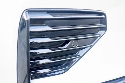 Selective focus on left side of front bumper decorative element parking sensor Stock Photos