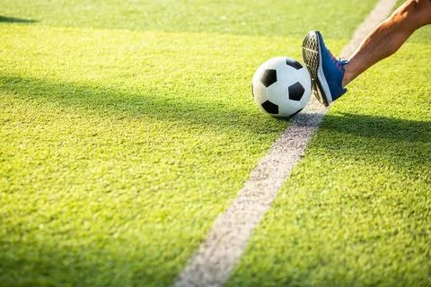 Selective focus to leg of soccer player placing a foot on a ball along the .. Stock Photos