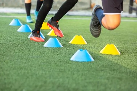 Selective focus to legs of young soccer players practicing agility drills, .. Stock Photos