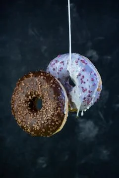 Selective focus, levitating sweet doughnuts with chocolate and blueberry icin Stock Photos