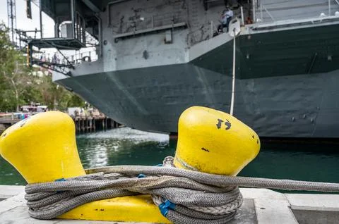 Selective focus on line securing a naval boat to a port bollard. Stock Photos