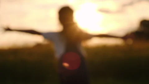 Selective focus of little girl running on background mountains and sky at sunset Stock Footage 246700760
