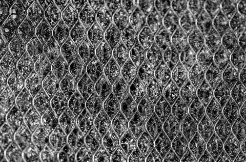 Selective focus macro of a dirty kitchen range hood filter clogged with grease. Foto stock