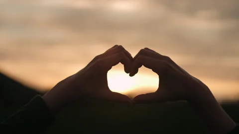 Selective focus of male hands in shape of love heart at amazing sunset Stock Footage 241492683