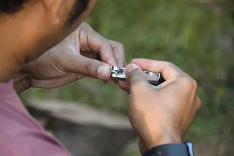 Selective focus of a man cut nails with nail clipper Stock Photos