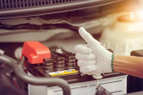 Selective focus, Man hand checking car battery on car engine system Stockfoto's