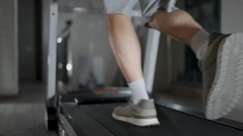 Selective focus of Man Legs Running on Treadmill in Gym. Low angle shot of .. Stock Footage 332335052