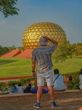 Selective focus on a man who is looking towards the Matrimandir temple in Aur Stock-Fotos