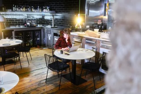 Selective focus on a manager working with a laptop inside a restaurant Stock Photos