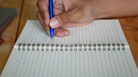 Selective focus of a man's hand writing on a notebook Stock Footage 103492673