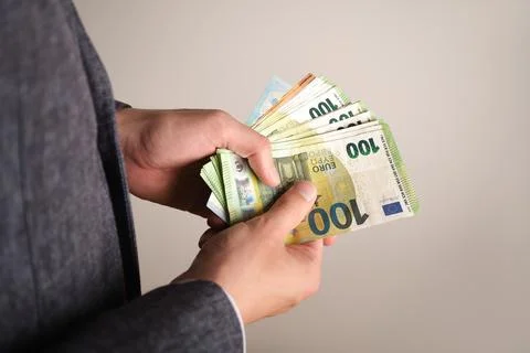 Selective focus of a man's hands counting euro banknotes. Stock Photos