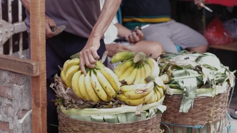Selective focus of a market vendor arranging banana in baskets at a fruit s.. Stock Footage 326313220