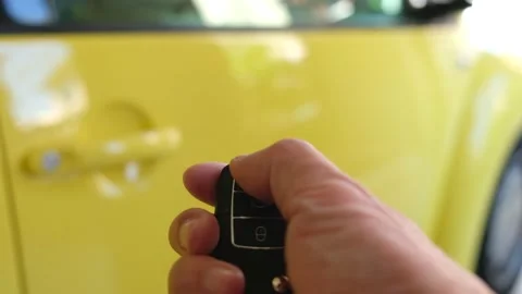 Selective focus at men hand press the button of car remote to unlock with bli Video stock 146363980