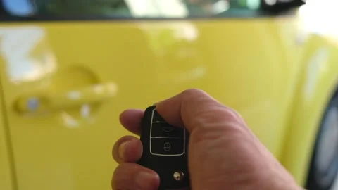 Selective focus at men hand press the button of car remote to unlock with bli Video stock 146363992