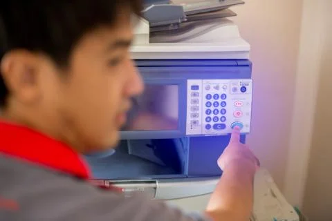 Selective focus to men press the button on panel of the copier and scanner. B Stock Photos