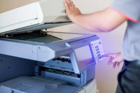 Selective focus to men press the button on panel of the copier and scanner. B Stock Photos