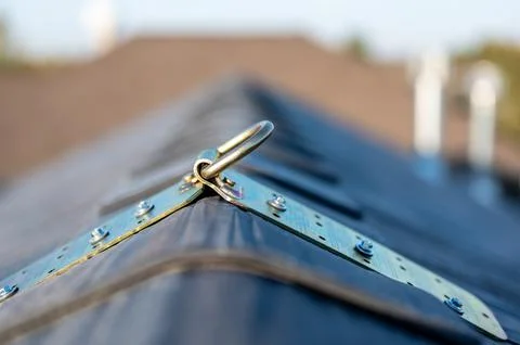 Selective focus on a metal temporary anchor installed on the peak of a roof for Stock Photos