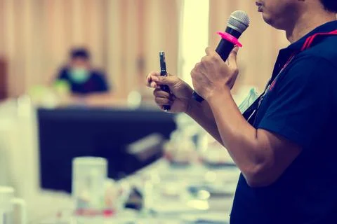 Selective focus to microphone in hand of speaker. 스톡 사진