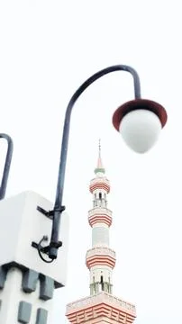 Selective focus. A minaret feature at mosque with a blurred vintage street light Stock Photos