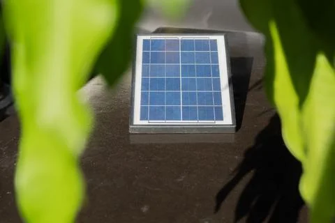 Selective focus of mini salar cell panel on the rock table in the garden. P.. Stock Photos