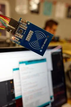 Selective focus of a module board against a blurry computer screen under mainten Stock Photos