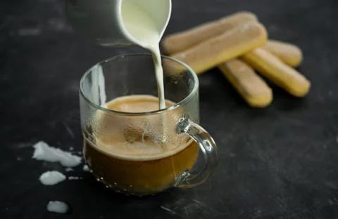 Selective focus, mug of hot coffee with cream and cookies Stock Photos