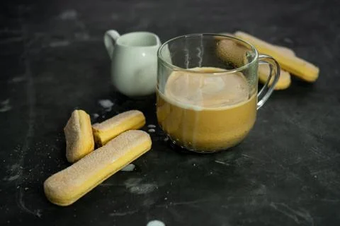 Selective focus, mug of hot coffee with cream and cookies Stock Photos