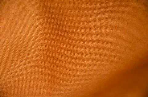 Selective focus of orange fabric with copy space. Bright textured tissue. Stock Photos