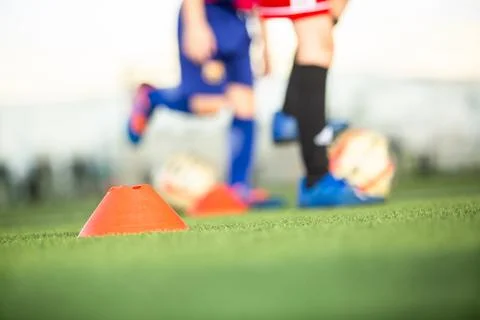 Selective focus to orange plastic training cone on green field with blurred.. Stock Photos