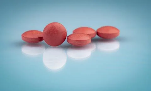 Selective focus on orange round tablets with shadow on gradient background. P Foto stock