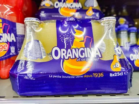 Selective focus on a pack of small bottles of orangina in the original format Stock Photos
