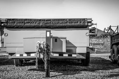 Selective focus on parked flat bed utility trailer with sides Stock Photos