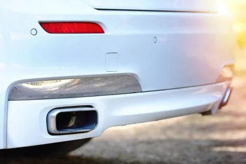 Selective focus on parking sensor exhaust pipe bumper at rear of white luxuri Stock Photos