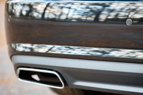 Selective focus on parking sensor exhaust pipe bumper at rear of black luxuri Stock Photos