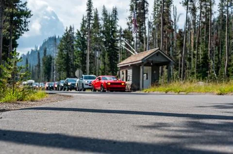 Selective focus on a paved road with a defocused long line of vehicles to enter Stock Photos