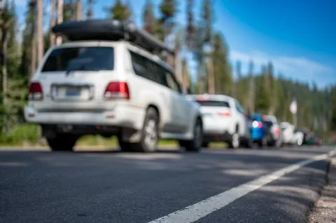 Selective focus on a paved road with a defocused long line of vehicles to enter Foto stock