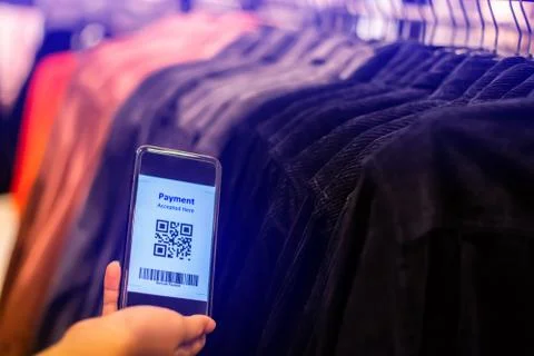 Selective focus to payment QR code tag on smartphone with blurry many clothes Stock Photos