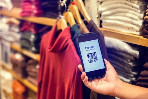 Selective focus to payment QR code tag on smartphone with blurry many clothes Stock Photos