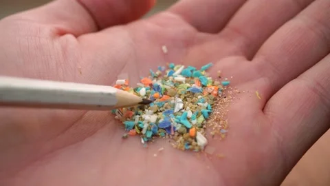 Selective focus of a person examining micro plastics in his hand with a penci Stock Footage 166973054