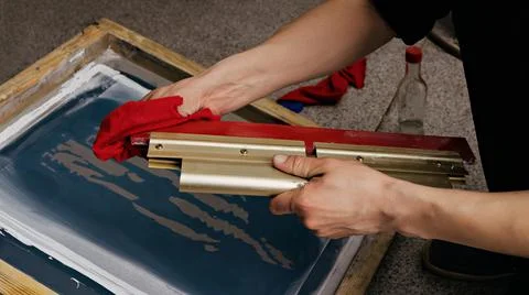 Selective focus photo of hands with squeegee. serigraphy production Stock Photos