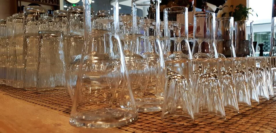 Selective focus. pile of empty transparent glasses on shelf. Close up of Stock Photos