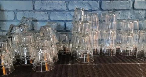 Selective focus. pile of empty transparent glasses on shelf. Close up of Stock Photos
