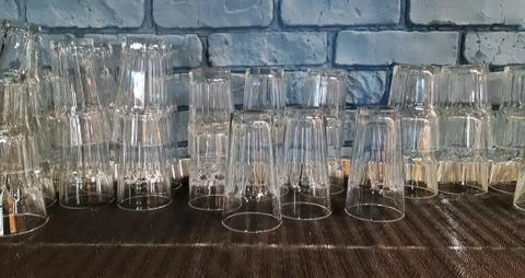 Selective focus. pile of empty transparent glasses on shelf. Close up of Stock Photos